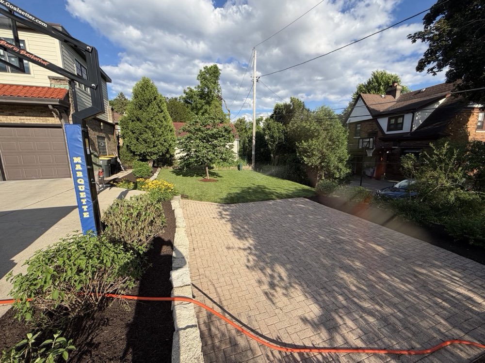 Finished Milwaukee landscape cleanup with stone retaining wall and lush plantings
